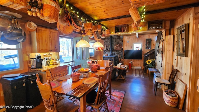 2124 Meadowlark Cir, Bushkill, PA 18324 - dining room with wooden walls, a wood stove, a baseboard heating unit, and wood finished floors