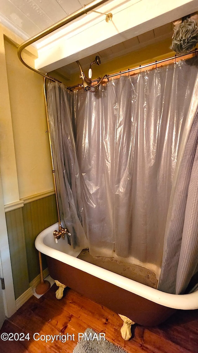 2124 Meadowlark Cir, Bushkill, PA 18324 - bathroom featuring a wainscoted wall, wood finished floors, and shower / bath combination with curtain