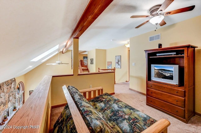 living area with vaulted ceiling with skylight, carpet, visible vents, and baseboards