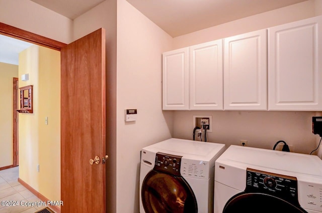 clothes washing area featuring cabinet space, independent washer and dryer, baseboards, and light tile patterned floors