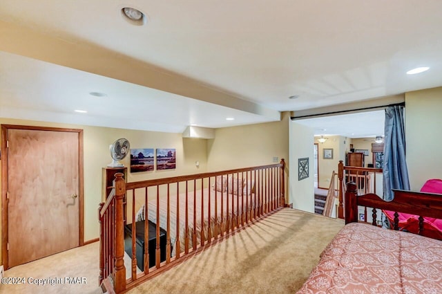 corridor with recessed lighting, an upstairs landing, and light colored carpet