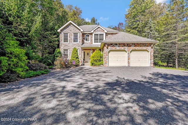 view of front of house with stone siding, driveway, and an attached garage