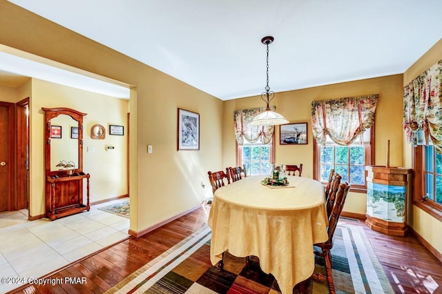 dining space featuring light wood-style floors and baseboards