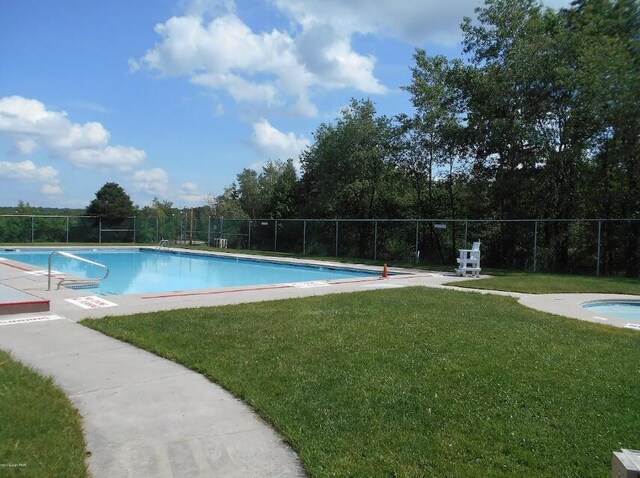 pool with a yard and fence