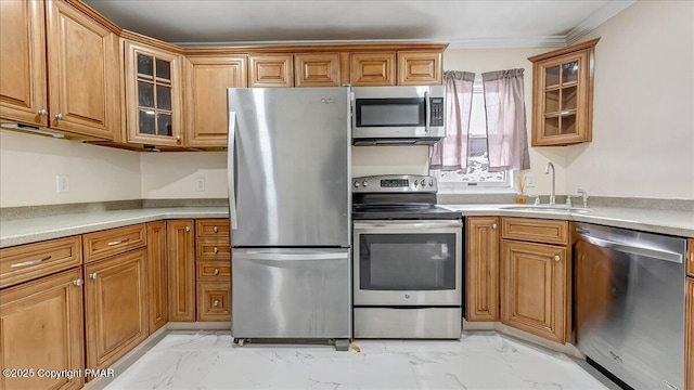 115 Aspen Cir E, Stroudsburg, PA 18302 - kitchen with appliances with stainless steel finishes, light marble finish floors, brown cabinetry, and ornamental molding