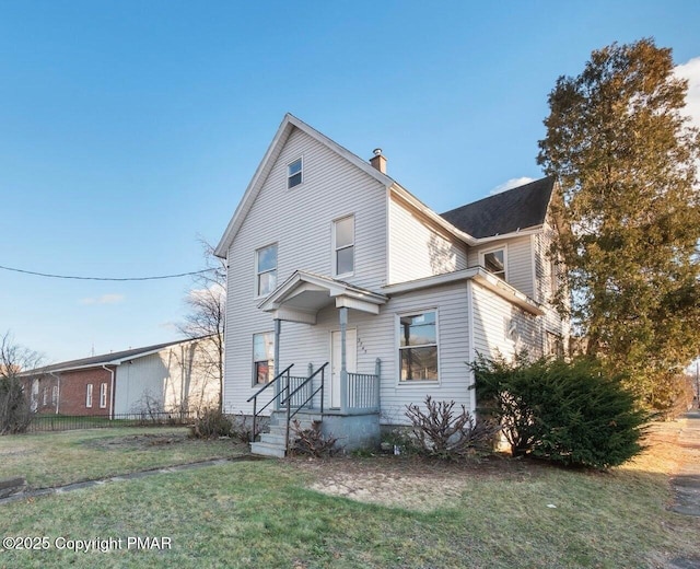 traditional home featuring a chimney and a front lawn