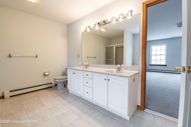 full bathroom with a baseboard heating unit, double vanity, and a sink