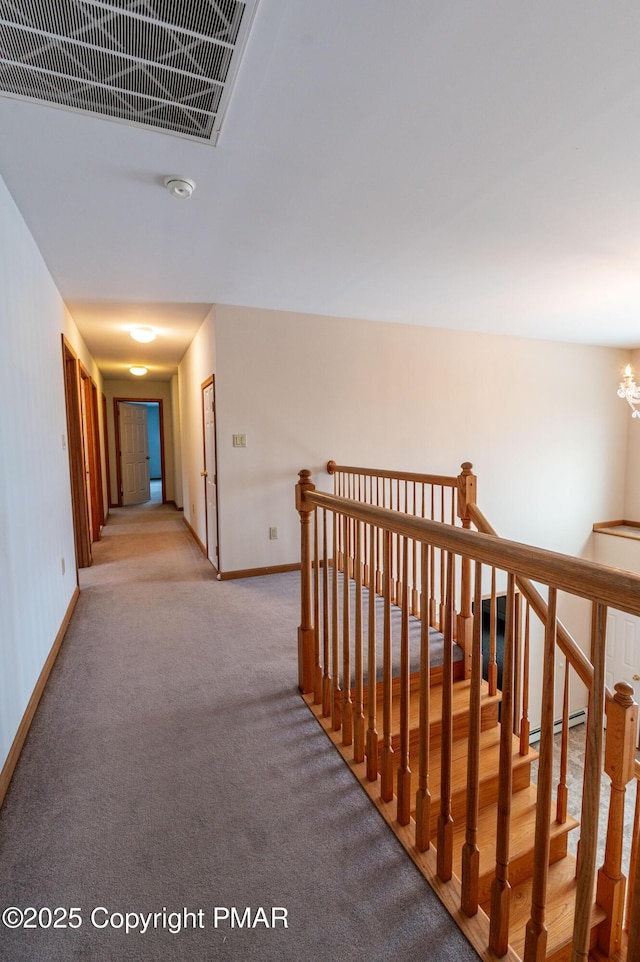 corridor with visible vents, baseboards, carpet, an upstairs landing, and an inviting chandelier