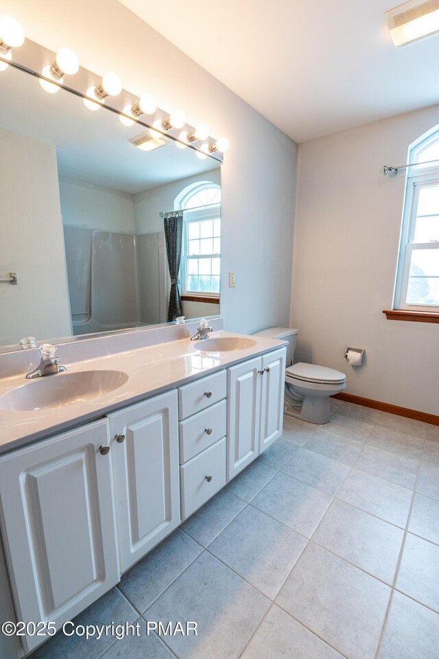 full bathroom with tile patterned flooring, a healthy amount of sunlight, and a sink