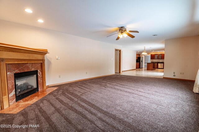 unfurnished living room featuring light carpet, a ceiling fan, recessed lighting, a fireplace, and baseboards