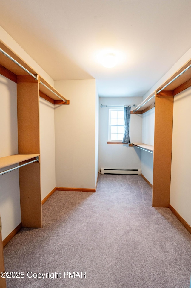 walk in closet with a baseboard radiator and carpet