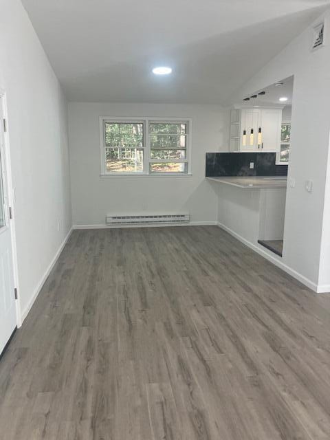 3354 Trafalgar Ave, East Stroudsburg, PA 18302 - unfurnished living room featuring a baseboard heating unit, wood finished floors, recessed lighting, and vaulted ceiling