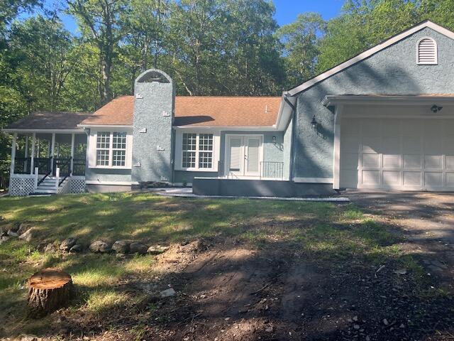 3354 Trafalgar Ave, East Stroudsburg, PA 18302 - single story home with a chimney, an attached garage, a front yard, a sunroom, and french doors