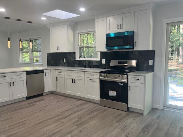 3354 Trafalgar Ave, East Stroudsburg, PA 18302 - kitchen featuring appliances with stainless steel finishes, light wood-style flooring, a skylight, backsplash, and recessed lighting