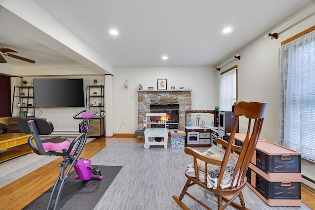 5286 Hilltop Cir E, Stroudsburg, PA 18301 - living area featuring wood finished floors, a ceiling fan, a stone fireplace, and recessed lighting
