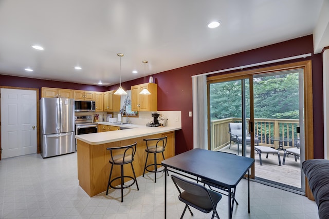5286 Hilltop Cir E, Stroudsburg, PA 18301 - kitchen with appliances with stainless steel finishes, a peninsula, recessed lighting, light countertops, and a kitchen bar