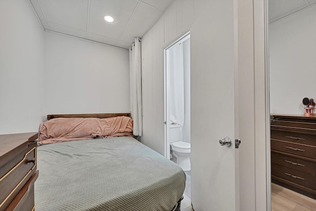 bedroom with connected bathroom and recessed lighting