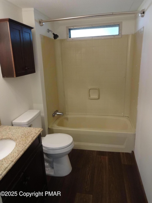 full bath with shower / bath combination, plenty of natural light, wood finished floors, and vanity