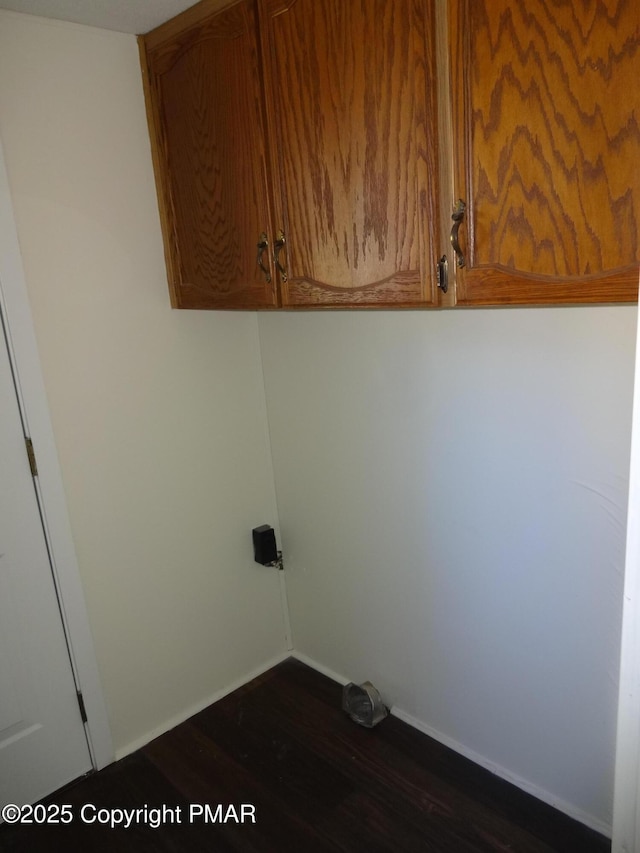 laundry room featuring dark wood-style floors, cabinet space, and baseboards