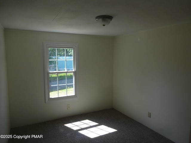 carpeted empty room featuring a water view and plenty of natural light