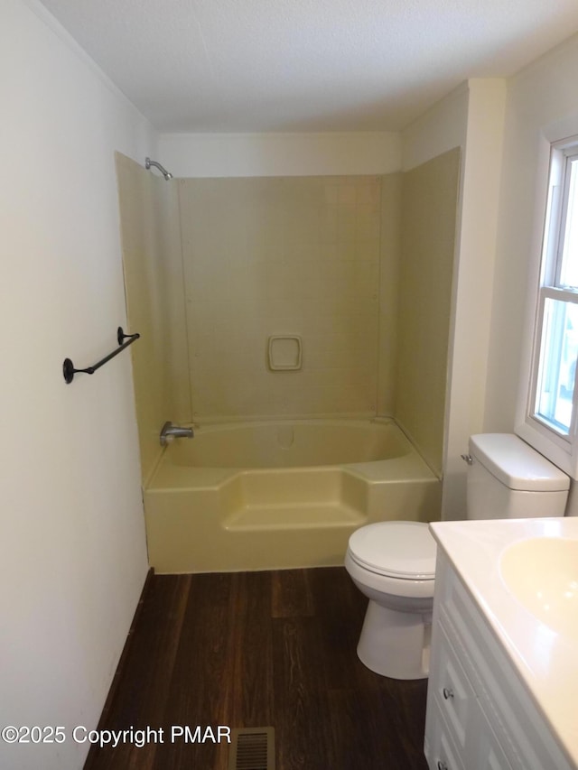 full bath featuring shower / bath combination, visible vents, toilet, wood finished floors, and vanity