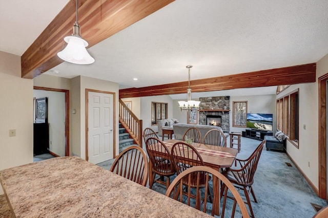 carpeted dining room with an inviting chandelier, a fireplace, baseboards, beamed ceiling, and stairway