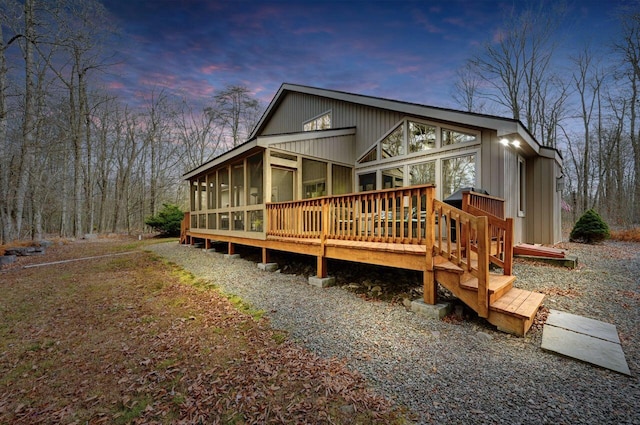 rear view of house with a wooden deck and a sunroom