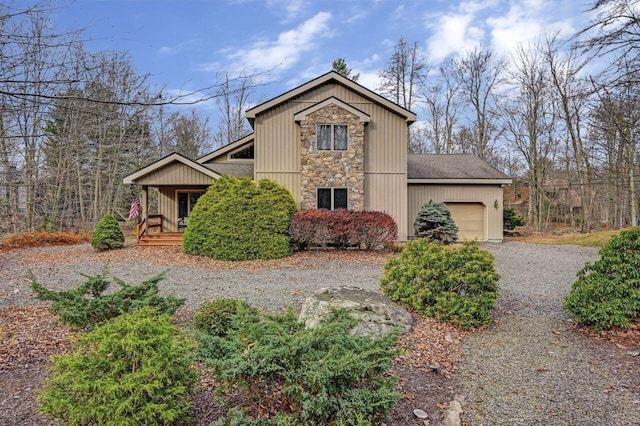 view of front of home with roof with shingles, an attached garage, driveway, and stone siding