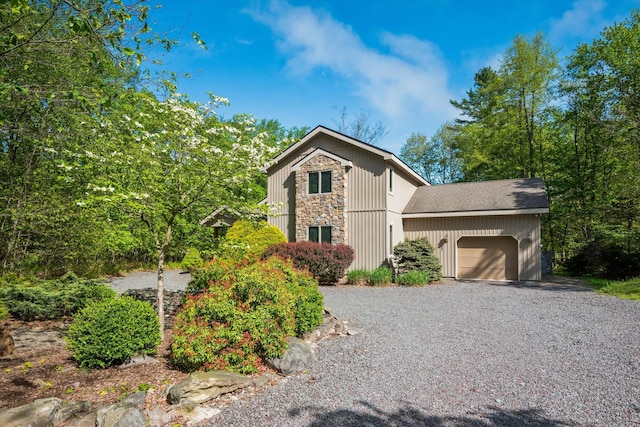 600 Conestoga Trl, Pocono Pines, PA 18350 - view of front of house featuring stone siding, an attached garage, and gravel driveway