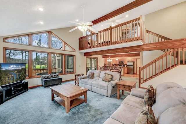 living room featuring light colored carpet, high vaulted ceiling, ceiling fan with notable chandelier, stairs, and recessed lighting