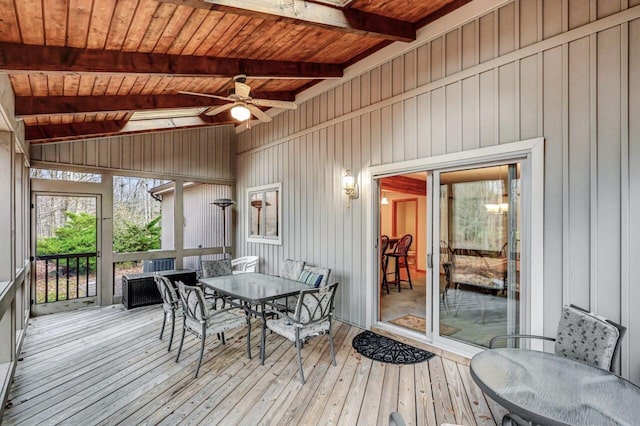 sunroom featuring ceiling fan, outdoor dining area, and beam ceiling