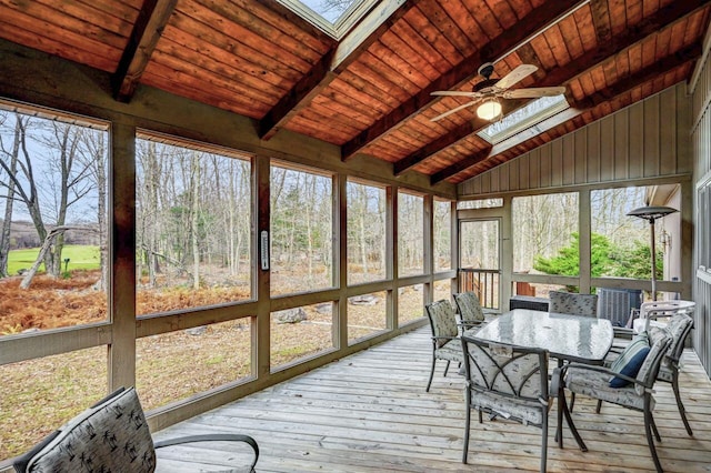 sunroom featuring outdoor dining space, ceiling fan, a skylight, and beamed ceiling