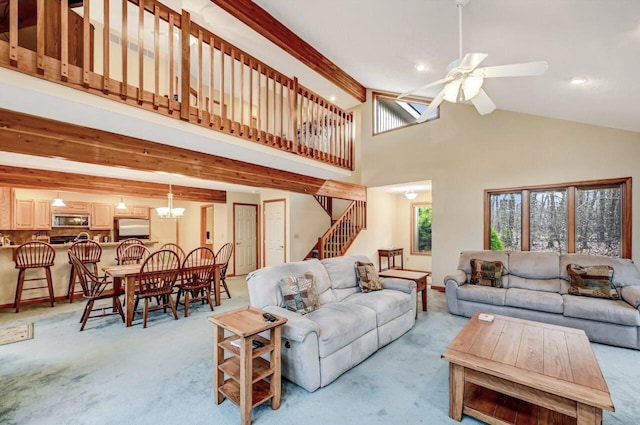 living area featuring stairs, beamed ceiling, light colored carpet, and high vaulted ceiling