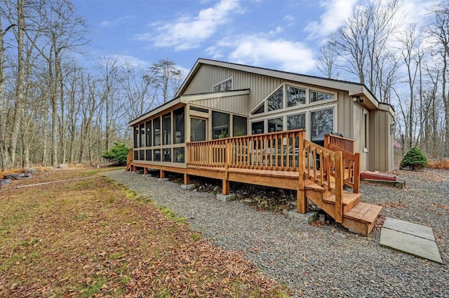 rear view of property featuring a wooden deck and a sunroom