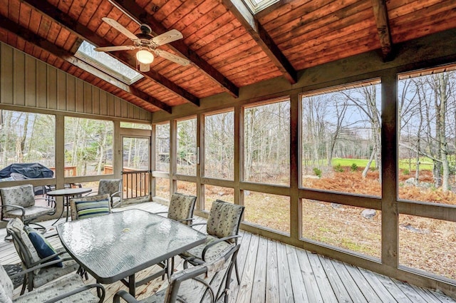 sunroom / solarium featuring outdoor dining area, a ceiling fan, a skylight, and beamed ceiling
