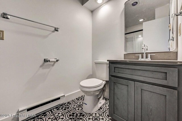 bathroom featuring vanity, tile patterned floors, baseboard heating, and toilet