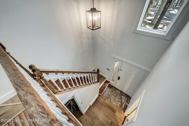 staircase with an inviting chandelier and hardwood / wood-style floors