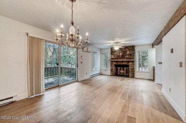 unfurnished living room with light hardwood / wood-style flooring, a fireplace, a wall mounted air conditioner, and a baseboard radiator