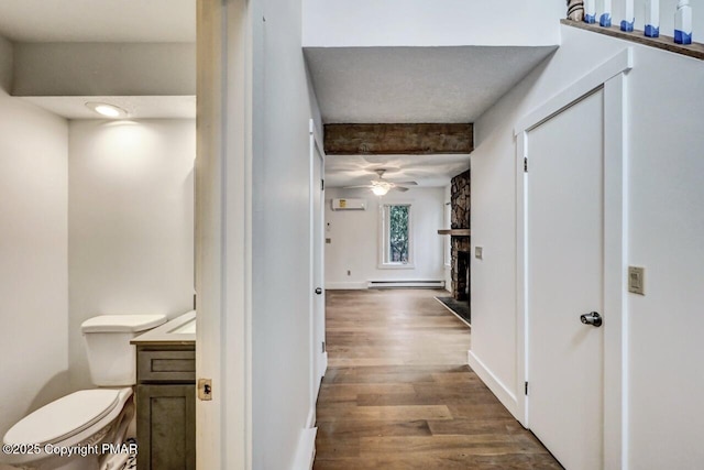 corridor with dark wood-type flooring and baseboard heating