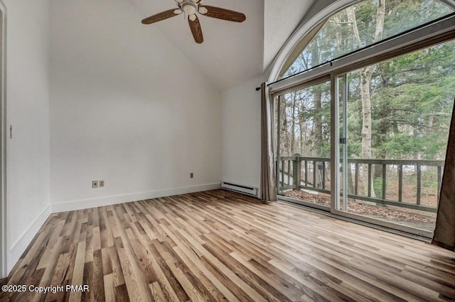 spare room with ceiling fan, a baseboard heating unit, high vaulted ceiling, and light wood-type flooring