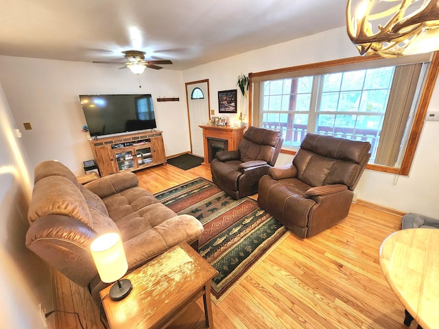 living area with a fireplace, baseboards, and wood finished floors