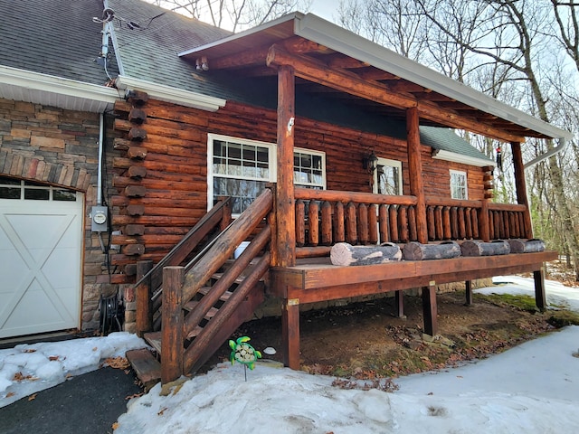 exterior space featuring a garage, a shingled roof, stone siding, log siding, and covered porch