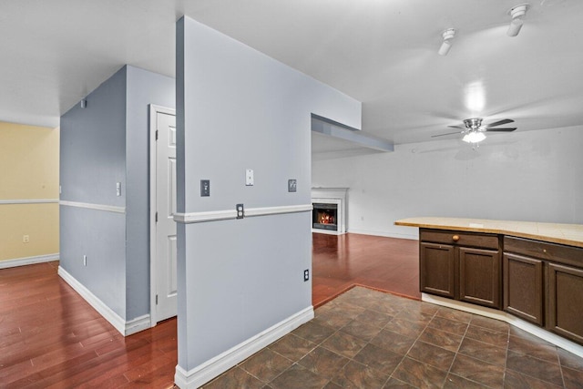 240 Timberline Dr, East Stroudsburg, PA 18301 - kitchen with ceiling fan, a lit fireplace, dark brown cabinetry, tile counters, and open floor plan