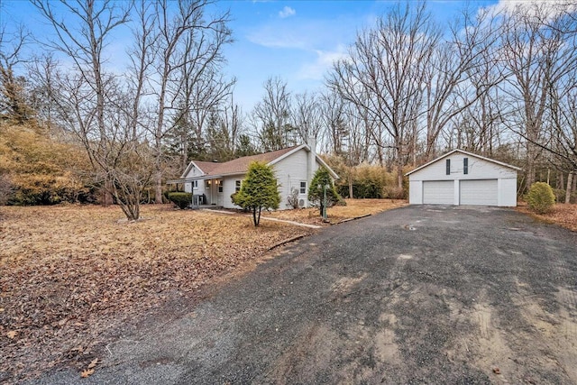 view of property exterior with a garage, an outdoor structure, and a chimney