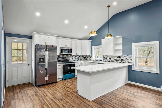 kitchen with stainless steel appliances, a peninsula, a sink, white cabinetry, and dark wood-style floors