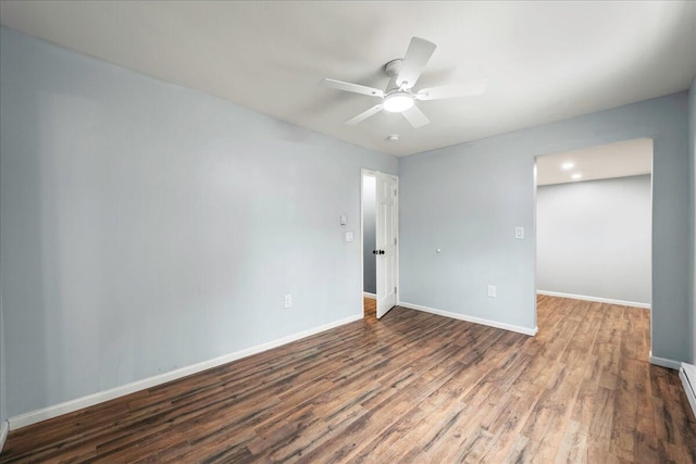 unfurnished room featuring a baseboard heating unit, ceiling fan, baseboards, and wood finished floors