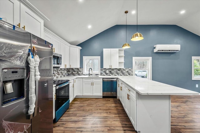 kitchen with open shelves, appliances with stainless steel finishes, an AC wall unit, a sink, and a peninsula