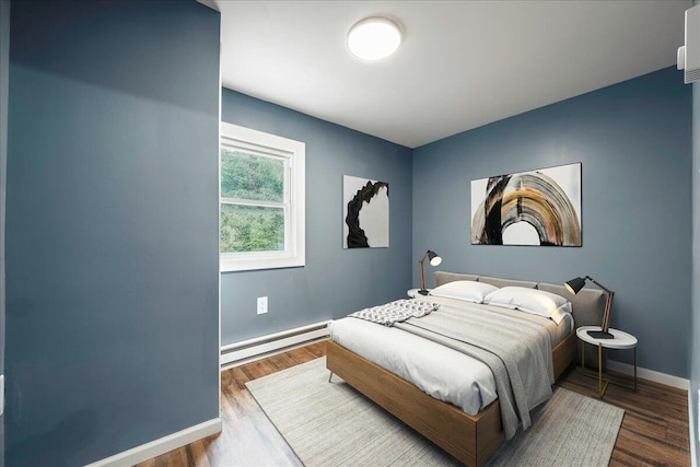 bedroom featuring a baseboard radiator, baseboards, and wood finished floors