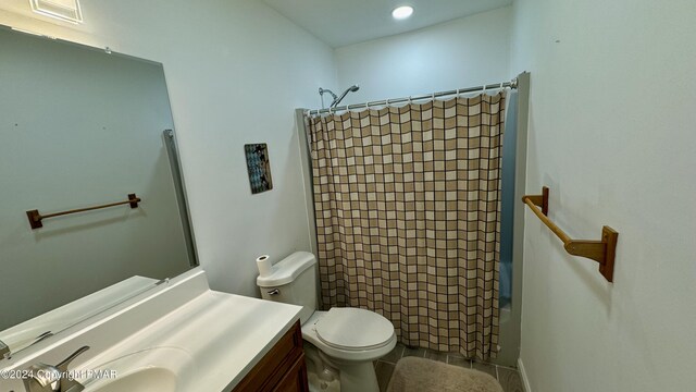 full bathroom featuring vanity, tile patterned floors, toilet, and shower / tub combo with curtain