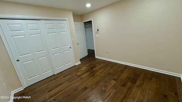 unfurnished bedroom with recessed lighting, a closet, baseboards, and dark wood-style flooring